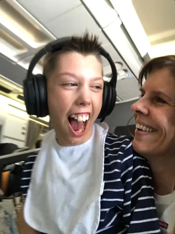 Mikkel med hodetelefoner ler høyt, med Lena tett inntil.
